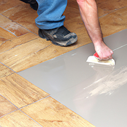 Man applying a primer to a tiled floor